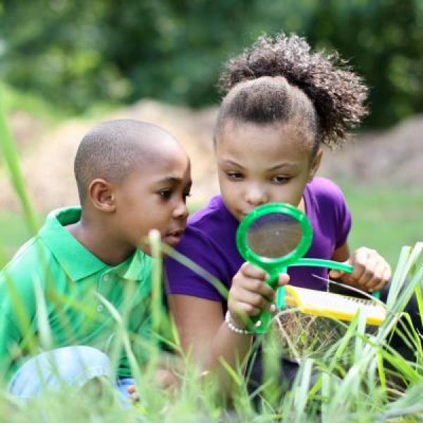 kids looking through a magnifying glass